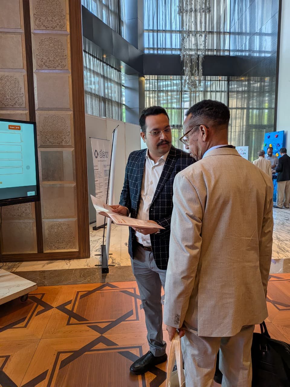 Extramarks team member taking a visitor through a brochure at WES Delhi 2026