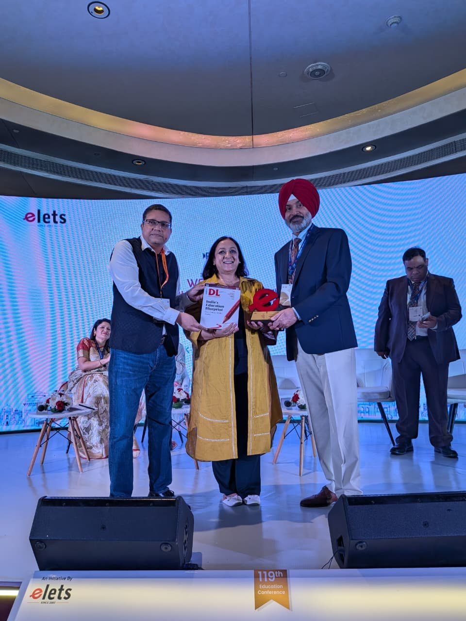 Panellist receiving a memento and the book India's Education Blueprint at WES Delhi 2026